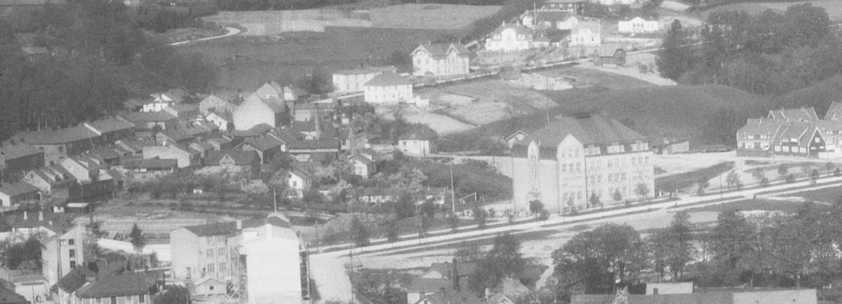 Bildet viser et utsnitt av Os-området rundt 1920-tallet. Vi ser Os Skole og Skofabrikken.